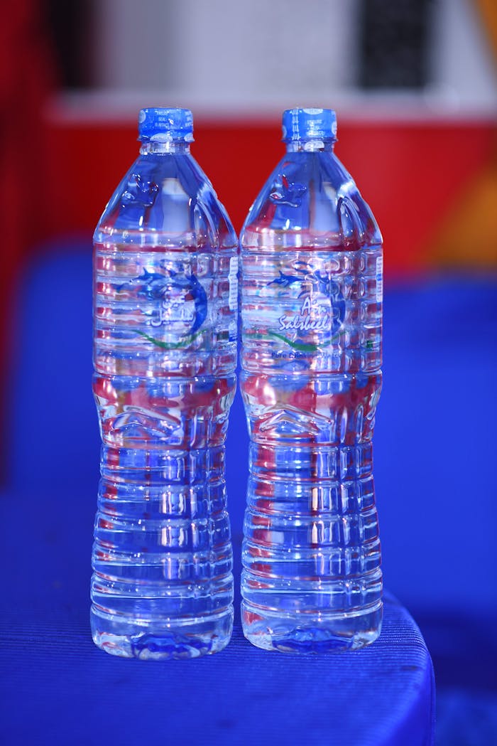 Crafting Captivating Headlines: Your awesome post title goes here Two plastic water bottles on a blue table with colorful backdrop.