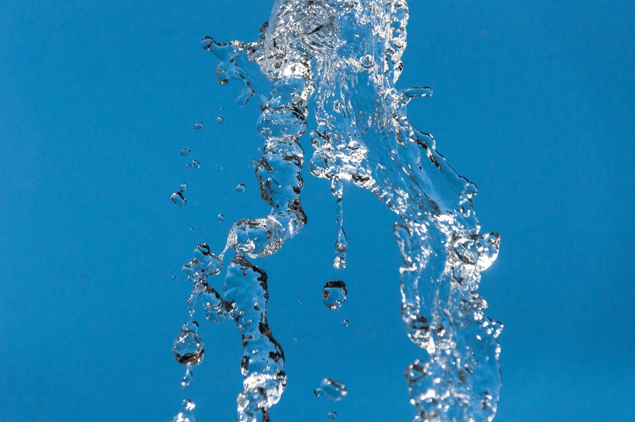 The Art of Drawing Readers In: Your attractive post title goes here A dynamic splash of clear water captured against a vibrant blue background, conveying freshness.